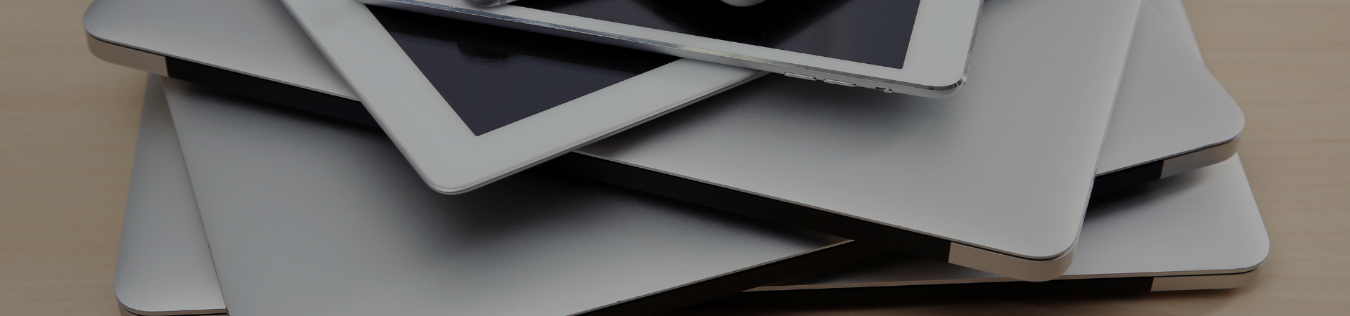 Page Header Image of laptops and tablet devices stacked on top of each other